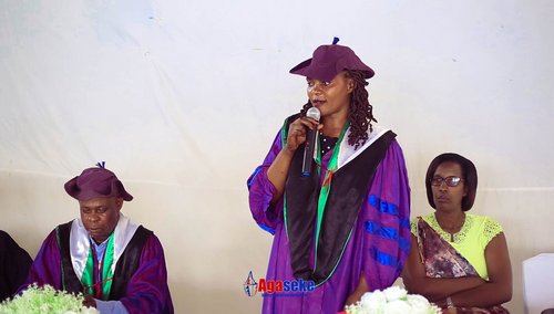Intervenante en toge violette de docteur s'exprimant au micro lors de la cérémonie